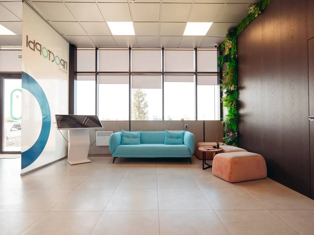 Лобби офиса продаж жилого квартала с зоной ожидания и стойкой с сенсорным экраном