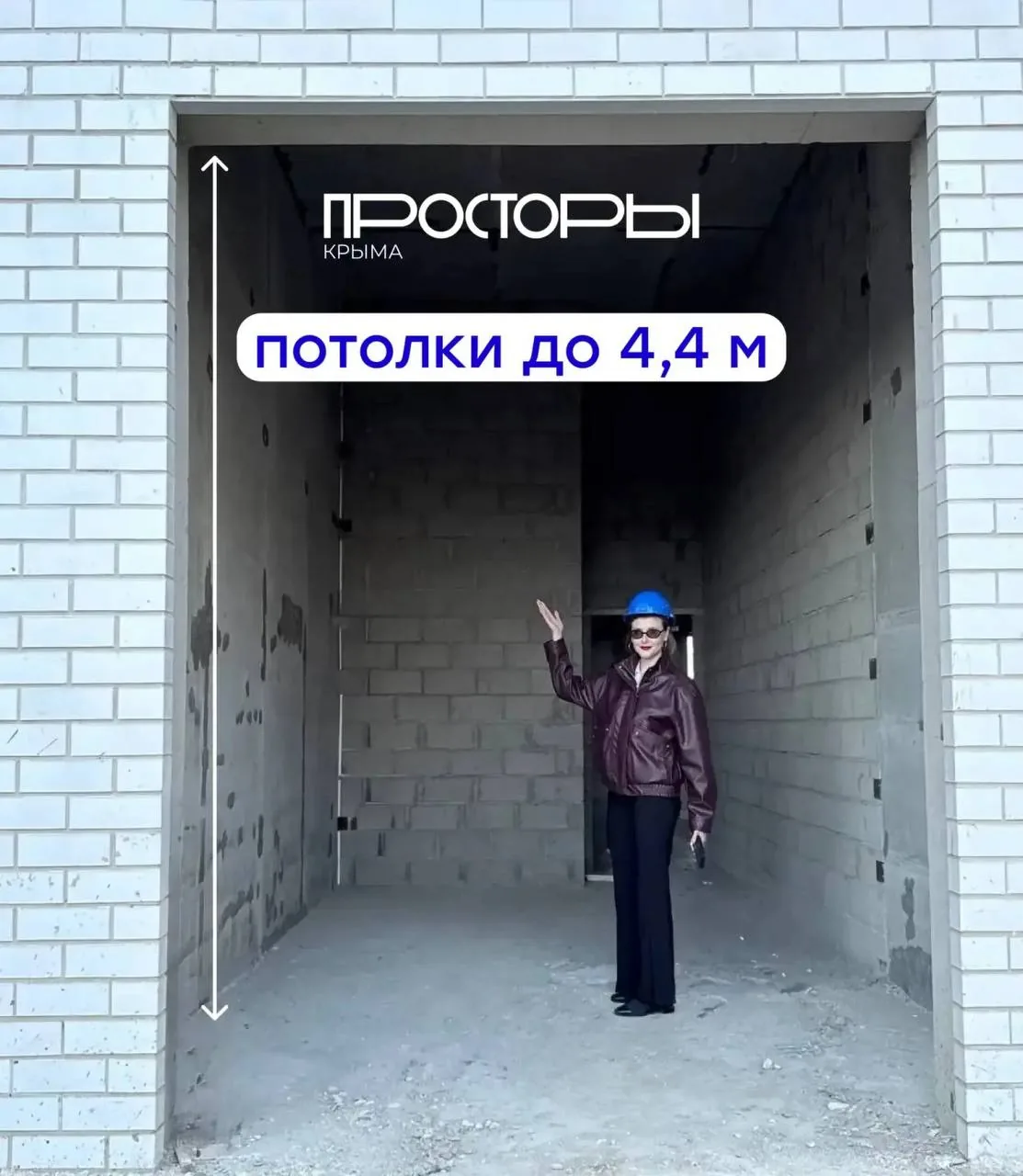 Специалист в каске на строительной площадке жилого квартала в процессе работ